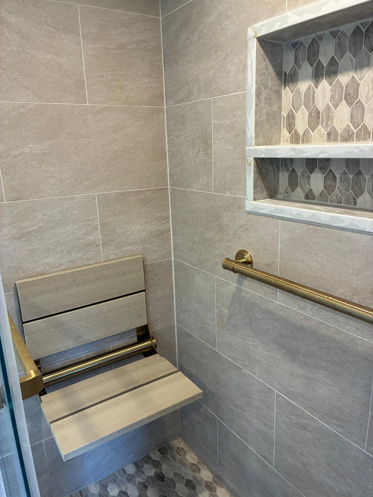 Luxury steam shower with built-in teak bench and mosaic tiling