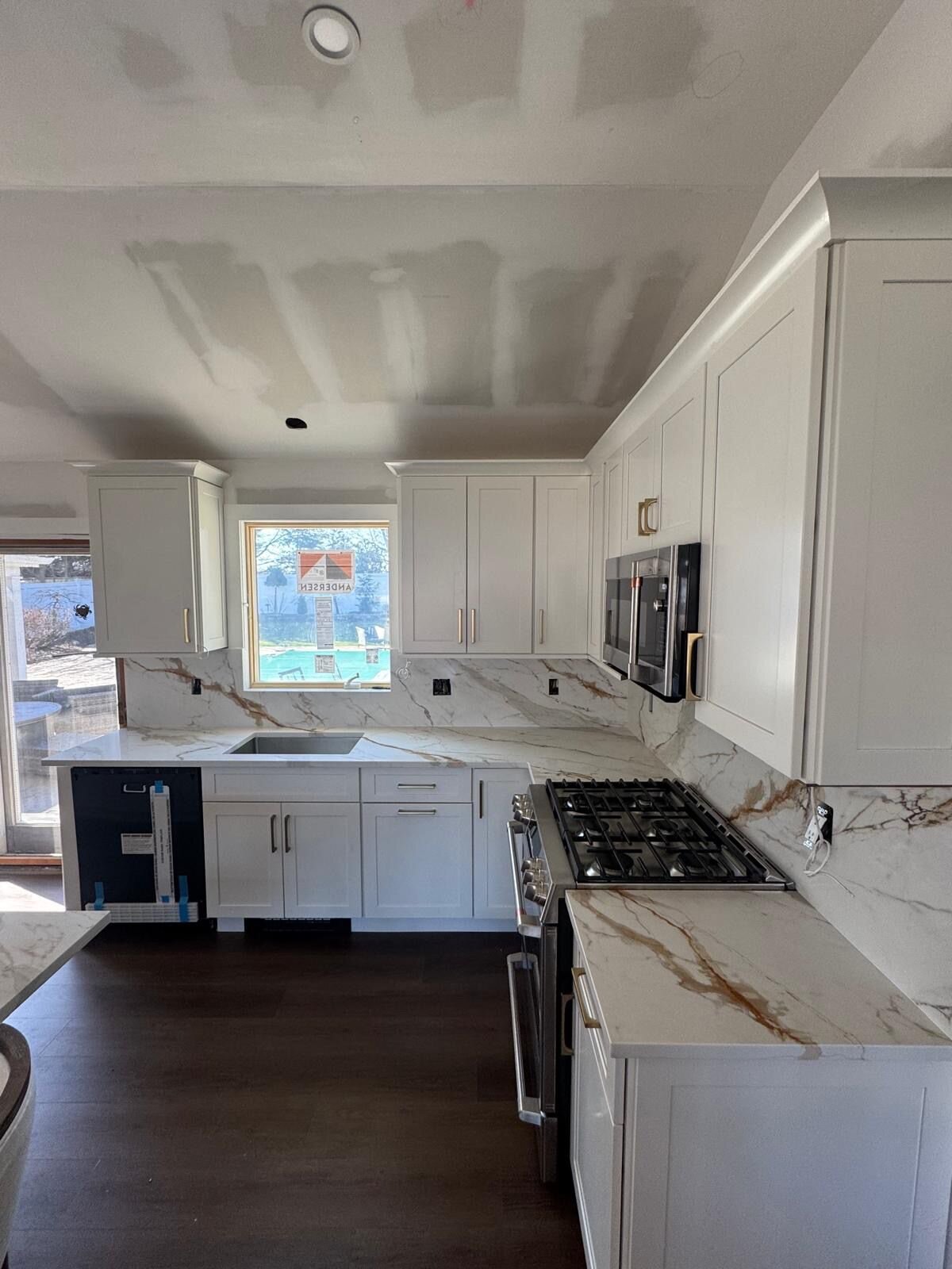 Finished kitchen with integrated appliances and custom wood cabinetry
