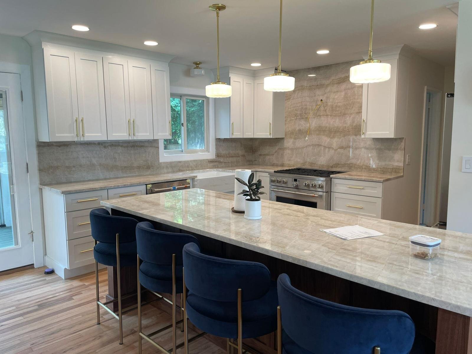Modern white kitchen with quartz island and navy accents