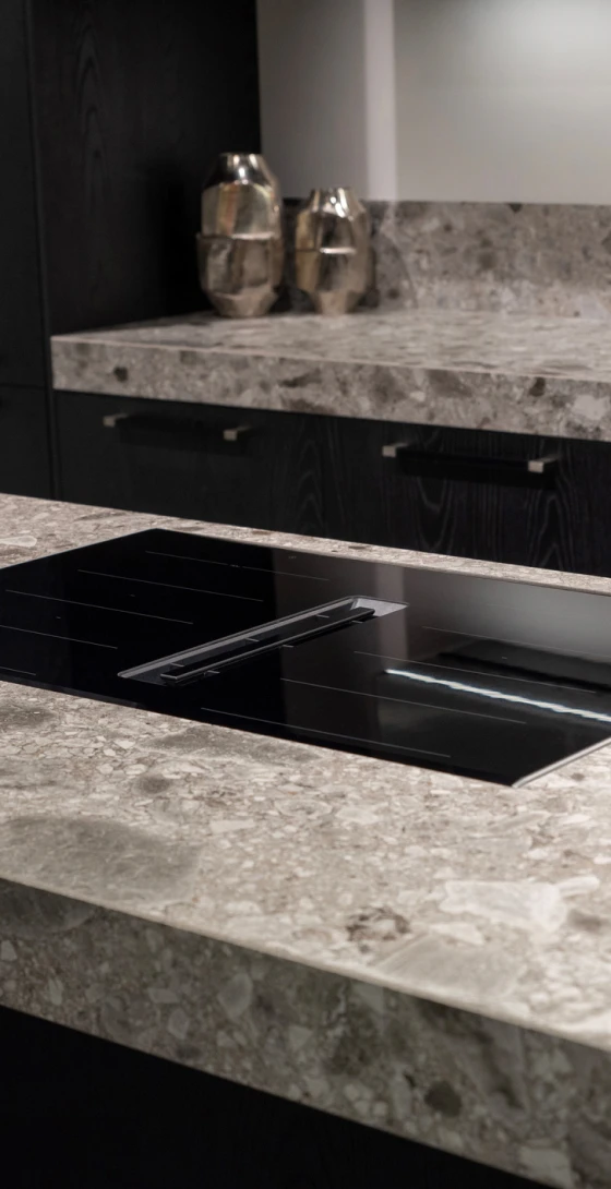 Textured grey stone countertop with cooktop