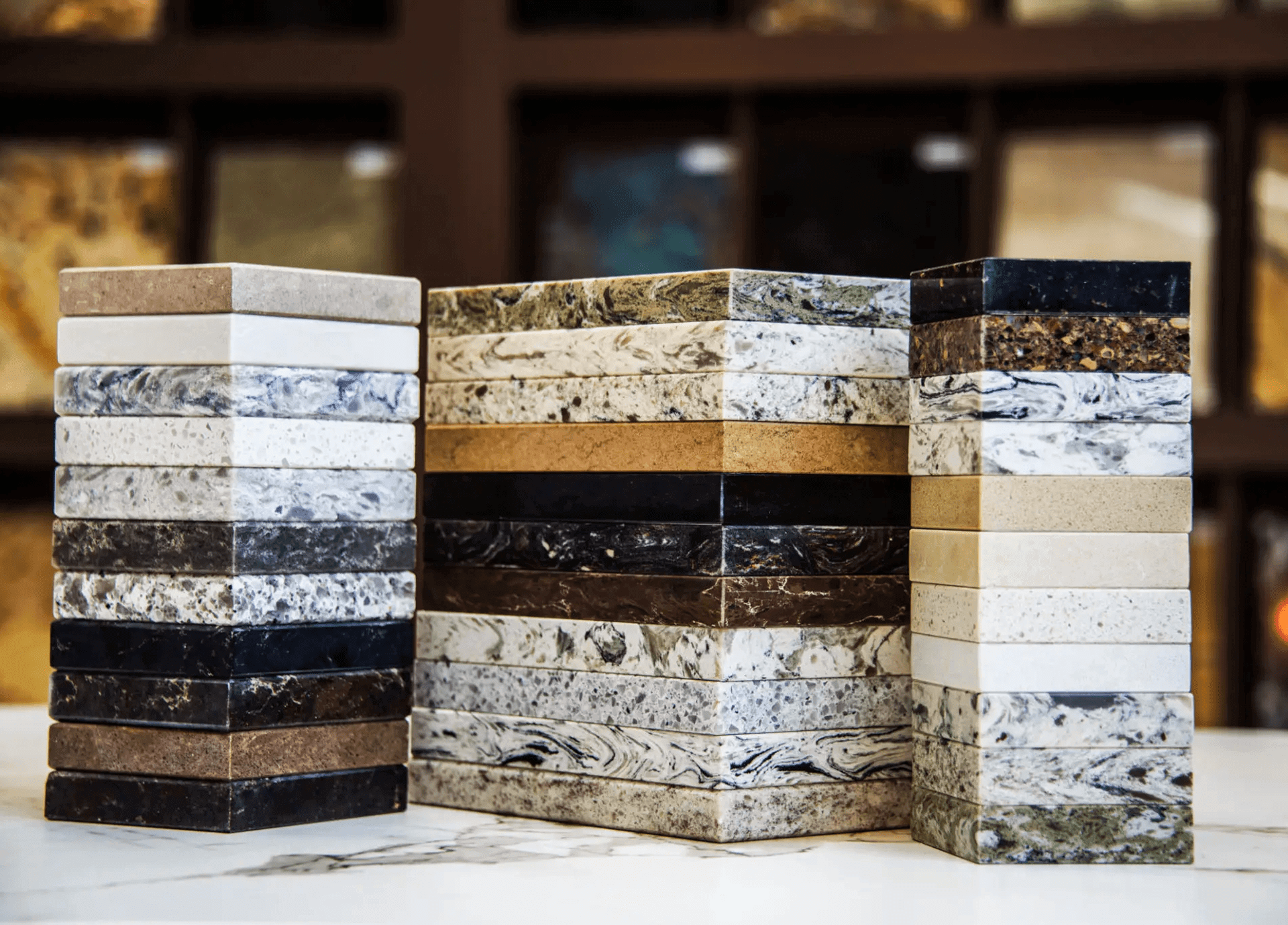 Stacks of stone and quartz countertop samples displayed on a table.